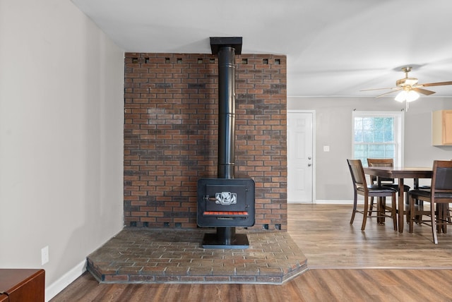 interior space featuring hardwood / wood-style floors, ceiling fan, and a wood stove