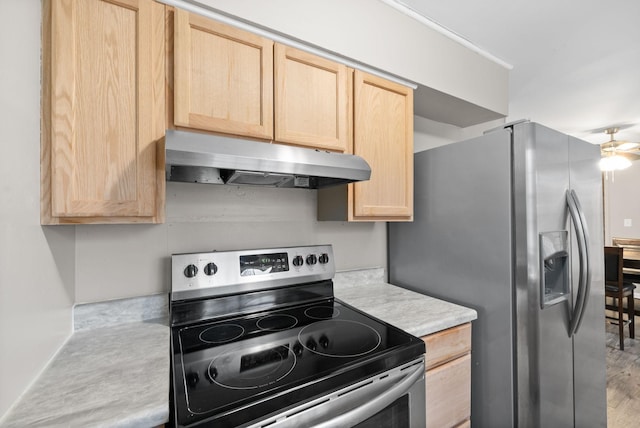 kitchen with light brown cabinets, stainless steel appliances, and light hardwood / wood-style floors