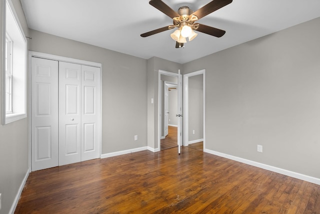 unfurnished bedroom featuring dark hardwood / wood-style flooring, a closet, and ceiling fan