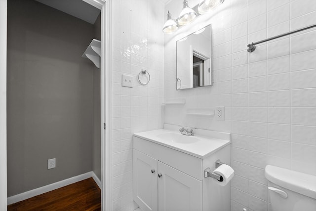 bathroom featuring hardwood / wood-style floors, vanity, toilet, and tile walls