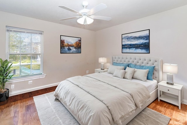 bedroom featuring multiple windows, hardwood / wood-style flooring, and ceiling fan