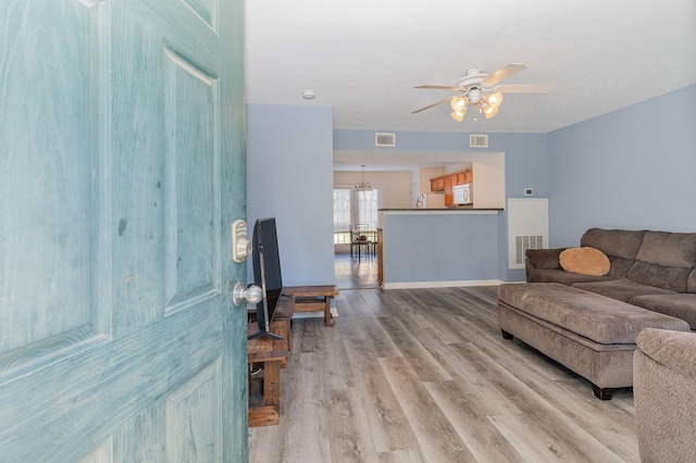 living room with ceiling fan and light hardwood / wood-style flooring