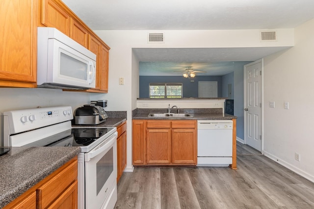 kitchen featuring ceiling fan, sink, white appliances, and hardwood / wood-style flooring