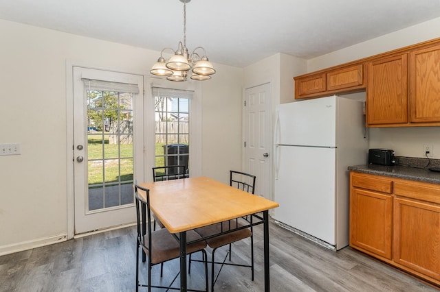 dining room featuring light wood-type flooring and an inviting chandelier