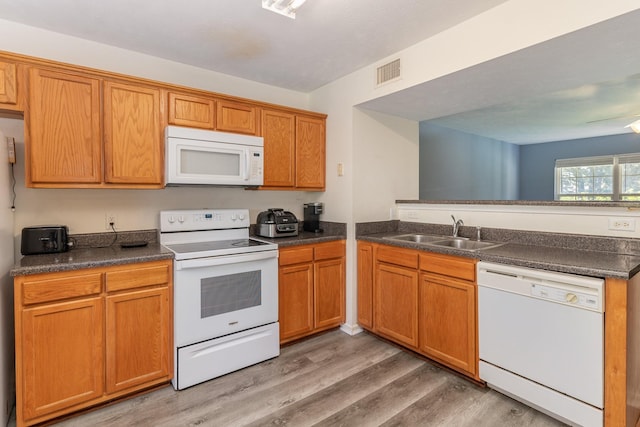 kitchen featuring kitchen peninsula, sink, light hardwood / wood-style floors, and white appliances