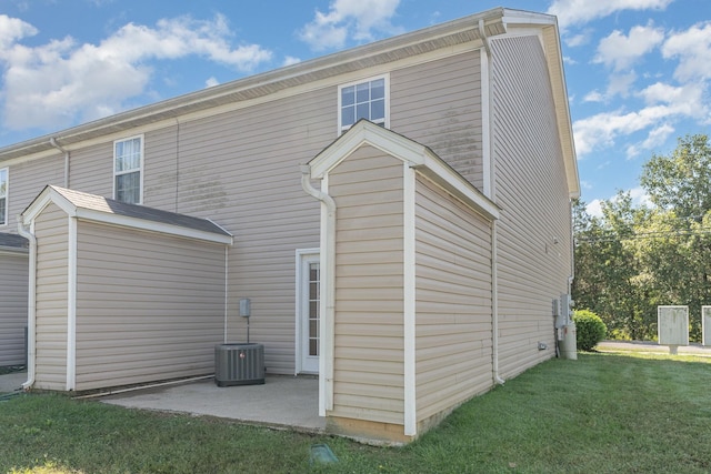 back of house featuring a lawn and a patio area