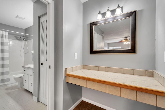 full bathroom with vanity, ceiling fan, shower / bath combo with shower curtain, tile patterned flooring, and toilet