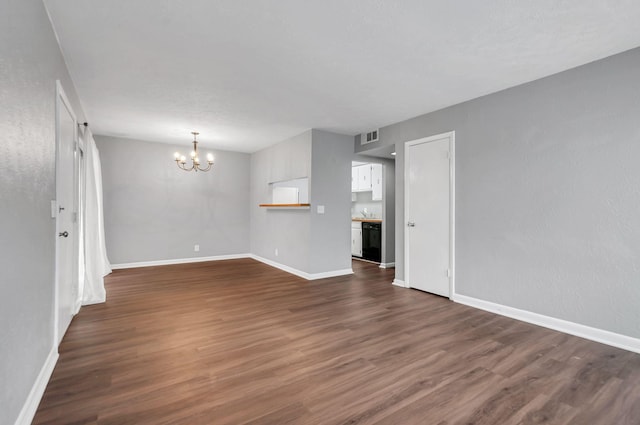 unfurnished living room with dark hardwood / wood-style floors and an inviting chandelier