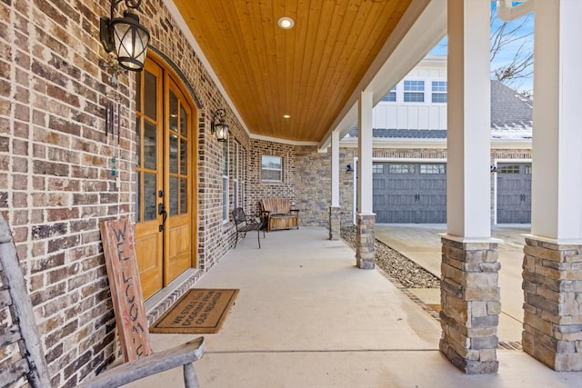 view of patio / terrace with a garage and a porch