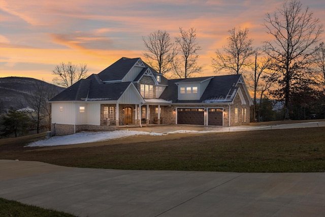 view of front of home with a mountain view, a yard, and a garage