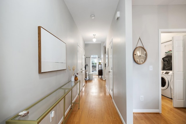 hallway with light hardwood / wood-style floors and washer / dryer