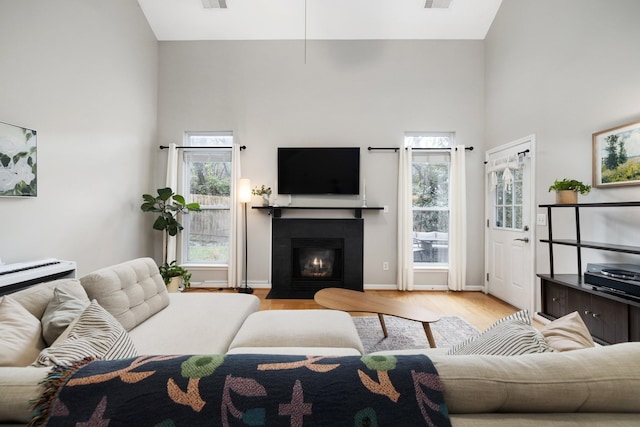 living room with light hardwood / wood-style flooring and high vaulted ceiling