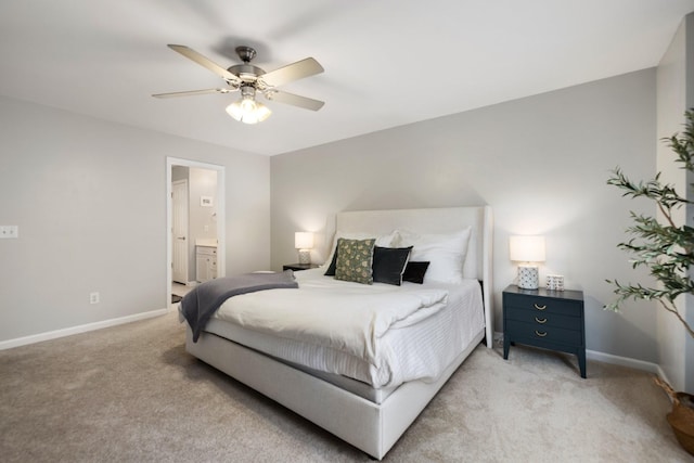 carpeted bedroom with ensuite bath and ceiling fan