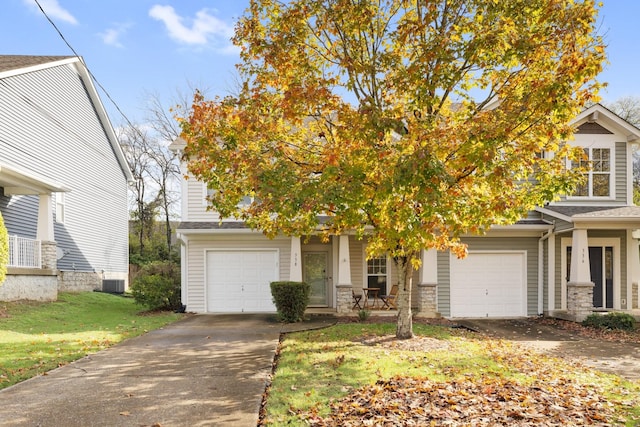 view of property hidden behind natural elements with central AC, a front lawn, and a garage