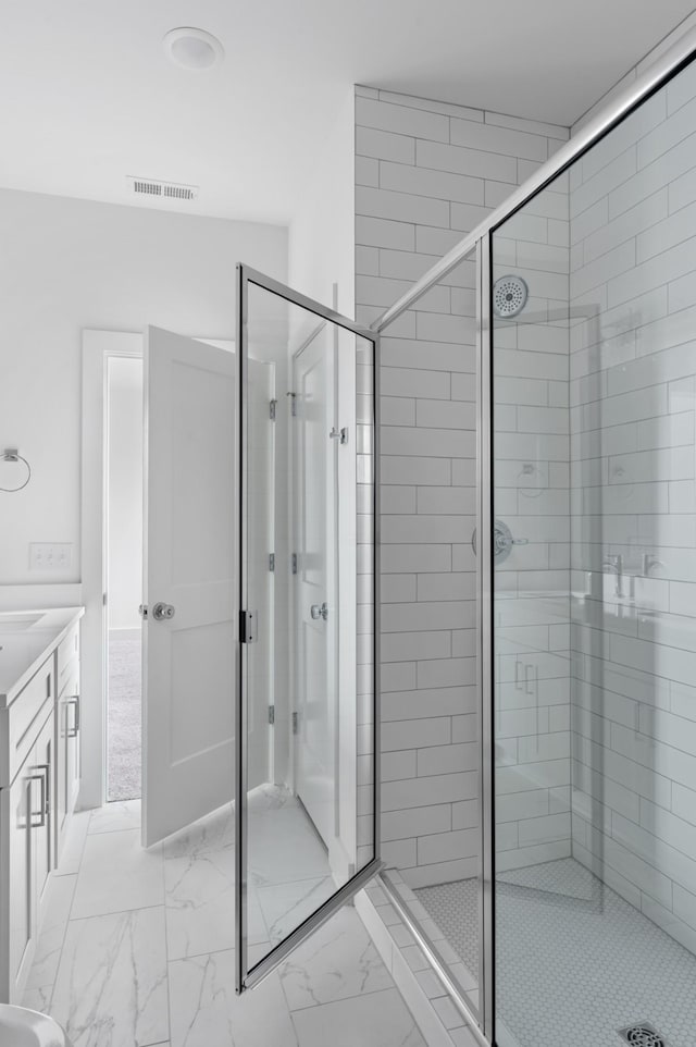 bathroom featuring a shower with shower door and vanity