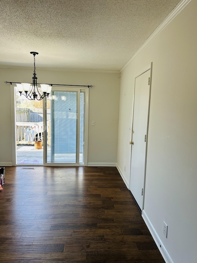 unfurnished room with a textured ceiling, dark hardwood / wood-style floors, crown molding, and a notable chandelier