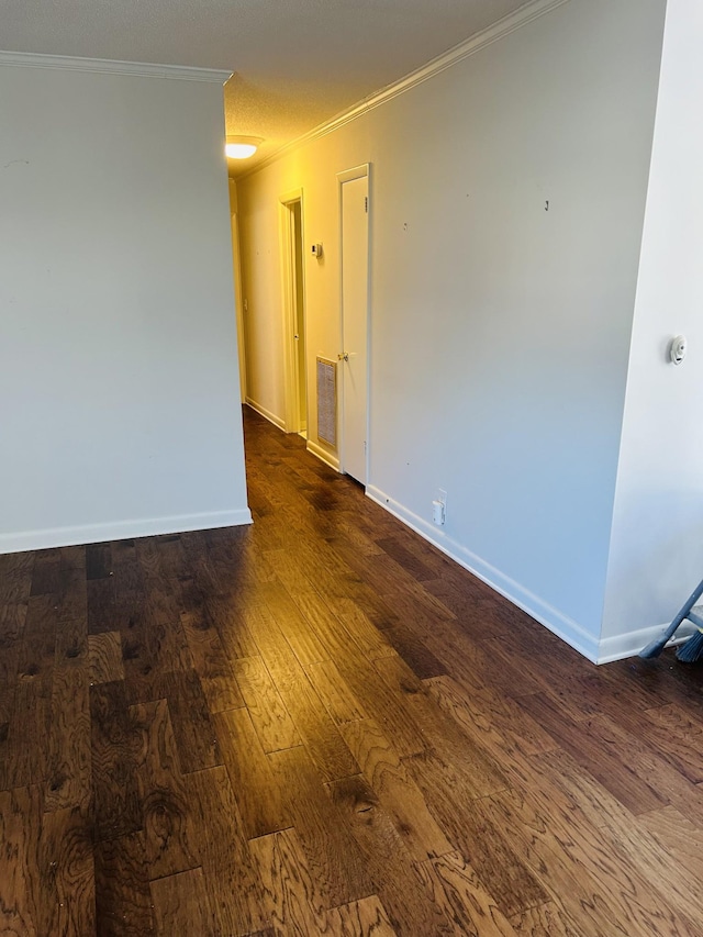 empty room with dark hardwood / wood-style floors and ornamental molding