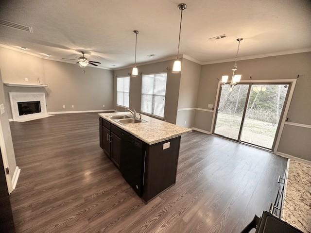 kitchen with ceiling fan with notable chandelier, crown molding, sink, dishwasher, and an island with sink