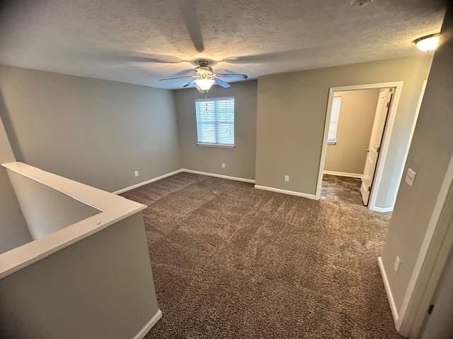 carpeted empty room with ceiling fan and a textured ceiling