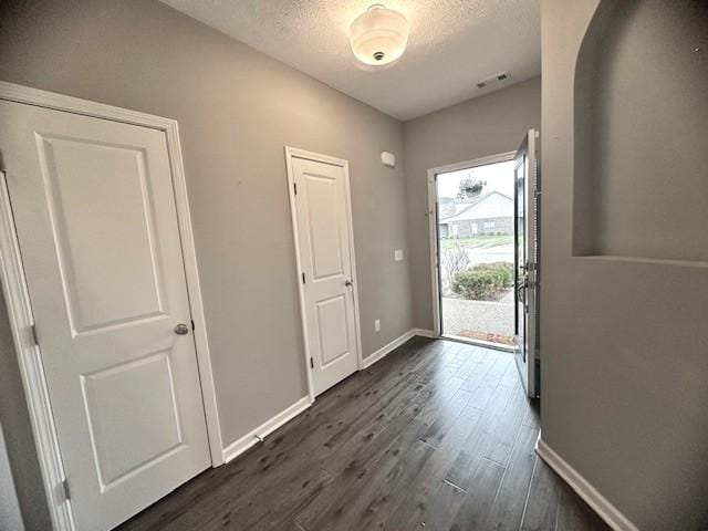 doorway featuring dark hardwood / wood-style flooring and a textured ceiling