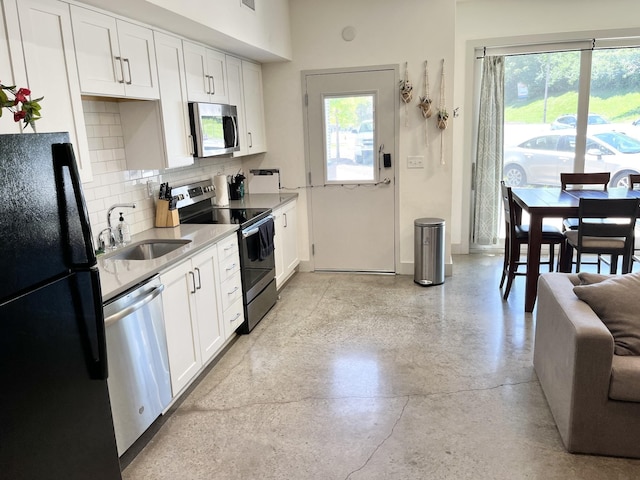 kitchen featuring white cabinets, stainless steel appliances, plenty of natural light, and sink