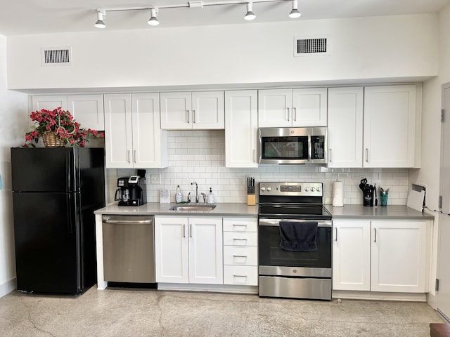 kitchen with tasteful backsplash, sink, white cabinets, and appliances with stainless steel finishes