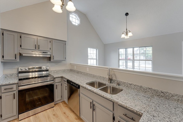 kitchen featuring light stone countertops, sink, pendant lighting, a chandelier, and appliances with stainless steel finishes