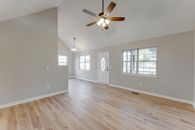 entrance foyer with high vaulted ceiling, light hardwood / wood-style floors, and ceiling fan with notable chandelier