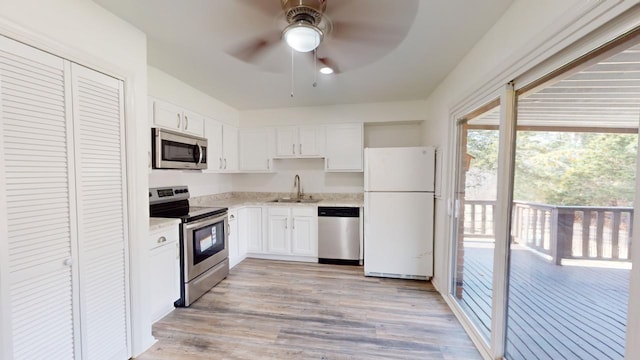 kitchen featuring white cabinets, sink, ceiling fan, light hardwood / wood-style floors, and stainless steel appliances