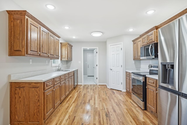 kitchen with light hardwood / wood-style floors, sink, and stainless steel appliances