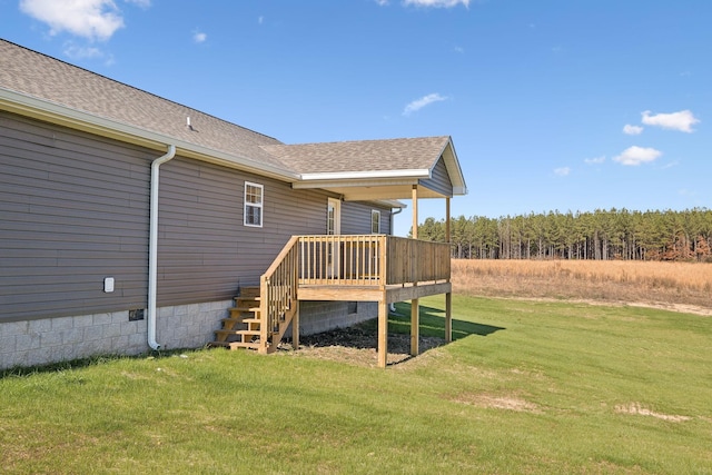 back of house featuring a deck and a lawn