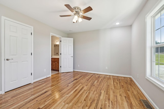 unfurnished bedroom featuring ceiling fan, light wood-type flooring, and ensuite bath