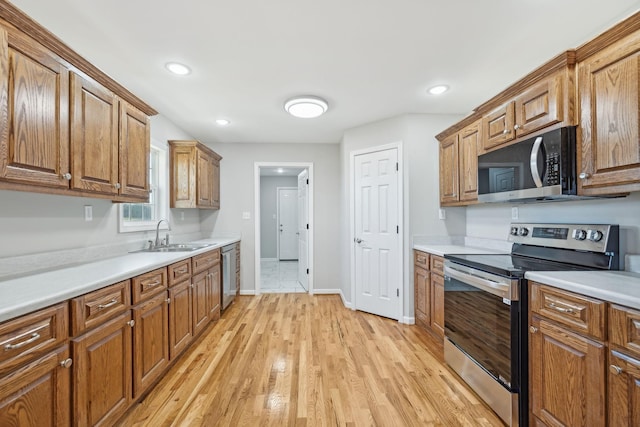 kitchen with sink, stainless steel appliances, and light hardwood / wood-style flooring