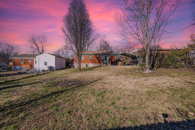 yard at dusk featuring a carport