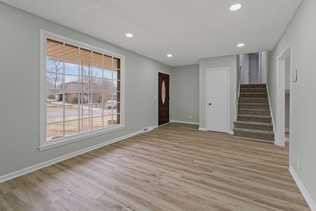 entryway with light hardwood / wood-style flooring and a textured ceiling