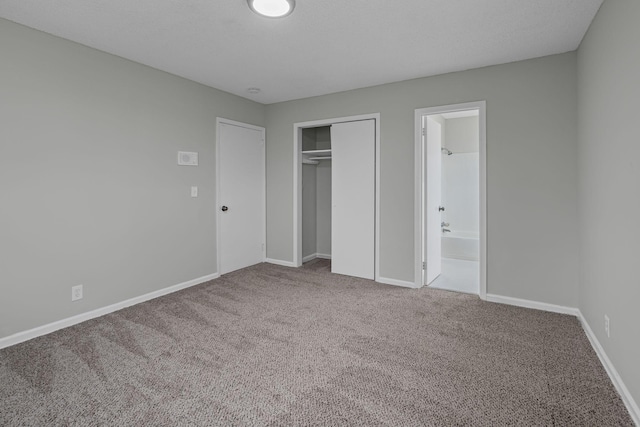 unfurnished bedroom with ensuite bathroom, carpet floors, and a closet