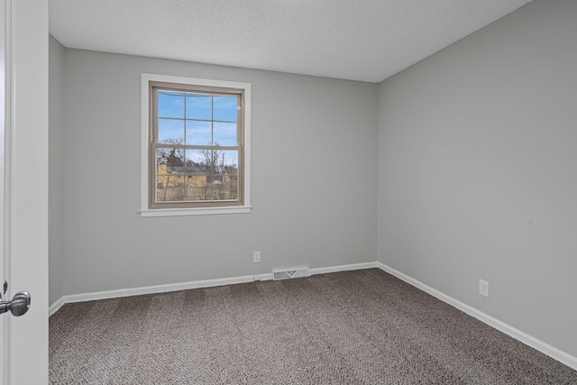 carpeted spare room with a textured ceiling