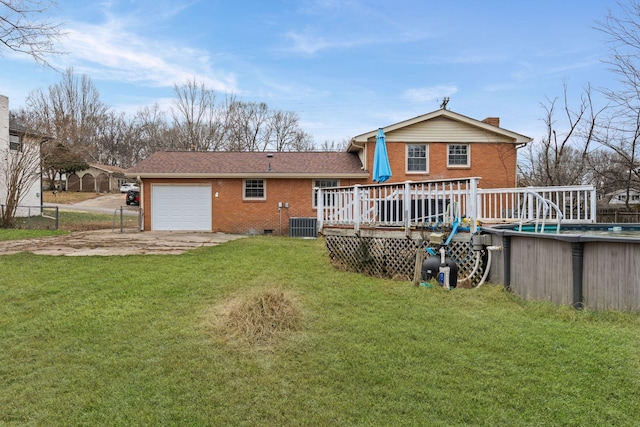 back of property featuring a garage, a swimming pool side deck, central AC, and a lawn