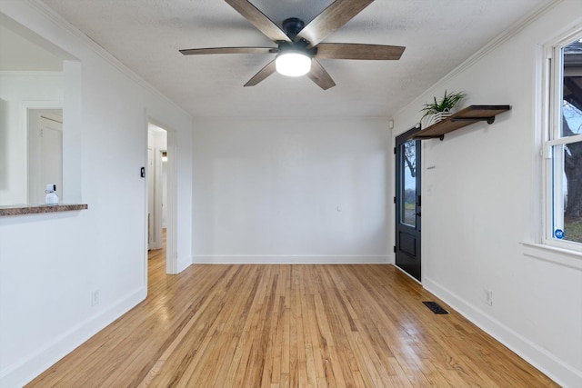 spare room with crown molding, ceiling fan, and light hardwood / wood-style flooring