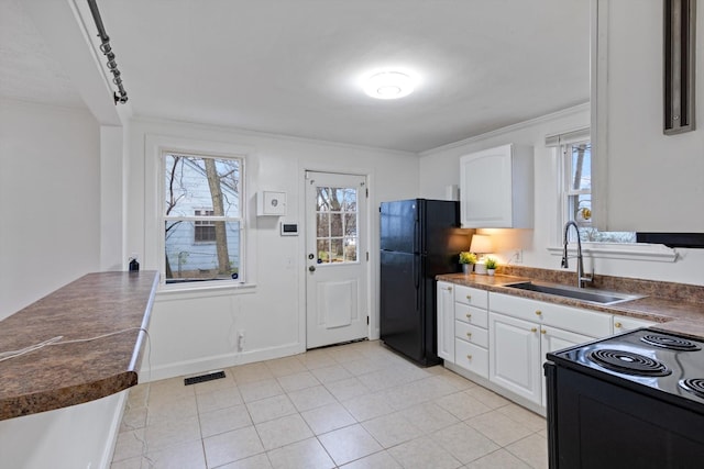 kitchen with white cabinets, black appliances, a healthy amount of sunlight, and sink