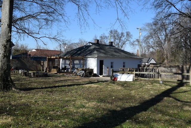 exterior space with stairway, a chimney, fence, and a lawn