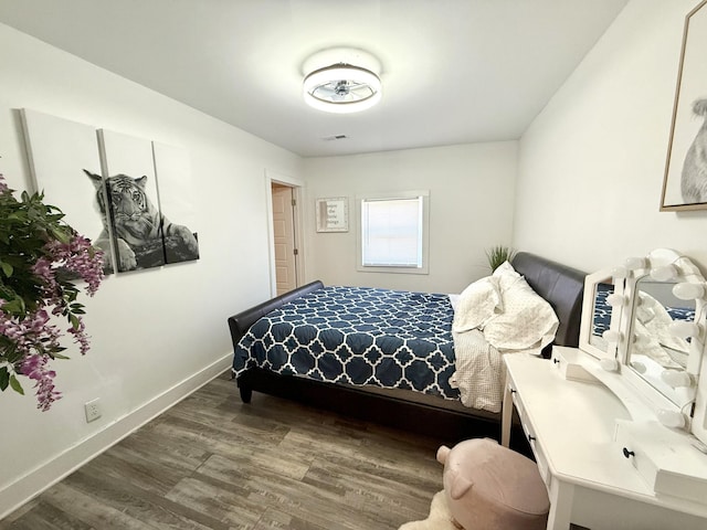 bedroom with baseboards and wood finished floors