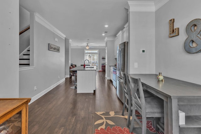 dining space with ceiling fan, dark hardwood / wood-style floors, sink, and crown molding