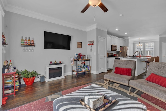 living room featuring ceiling fan with notable chandelier, dark hardwood / wood-style floors, crown molding, and sink