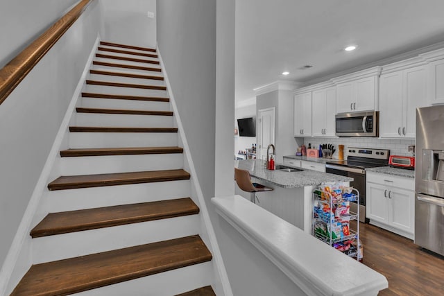 kitchen featuring sink, tasteful backsplash, dark hardwood / wood-style floors, white cabinets, and appliances with stainless steel finishes