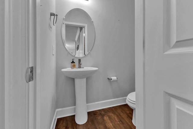 bathroom with hardwood / wood-style flooring, toilet, and sink