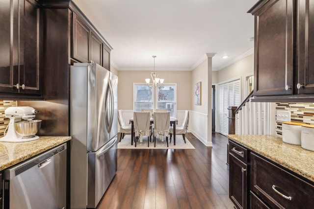 kitchen featuring pendant lighting, dark hardwood / wood-style floors, light stone counters, and stainless steel appliances