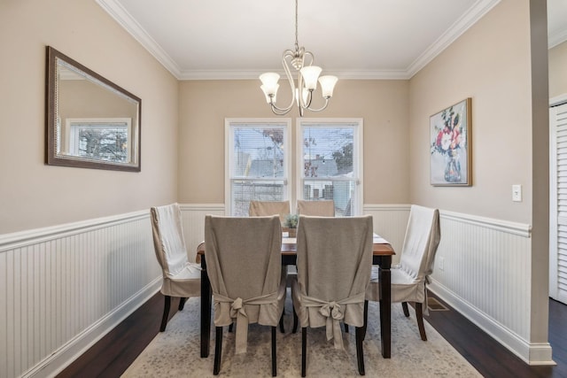 dining room with an inviting chandelier, dark wood-type flooring, and ornamental molding