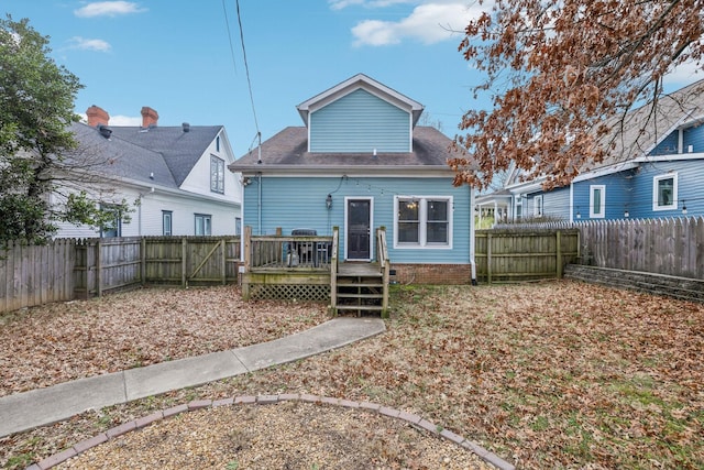 rear view of house featuring a wooden deck