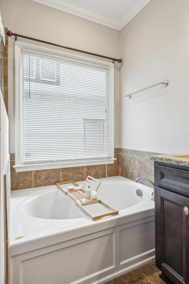 bathroom with plenty of natural light, a bathtub, ornamental molding, and vanity